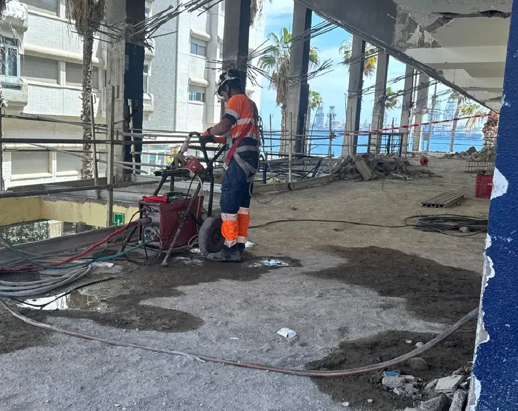 Operario de Eurocortes junto a equipo de corte en un edificio en rehabilitación.